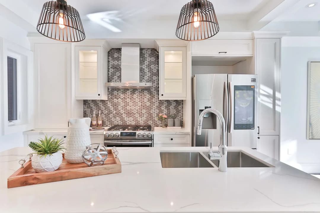 Modern kitchen with gray tile backsplash, stainless steel appliances, and a stylish island.
