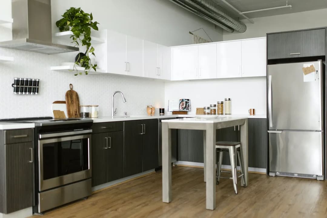 Modern kitchen with sleek cabinets, stainless steel appliances, and a stylish dining table.
