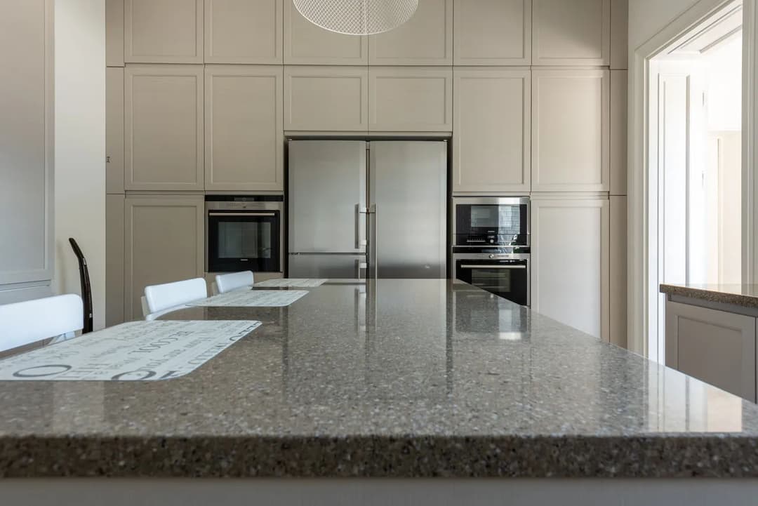 Modern kitchen with sleek appliances, quartz countertop, and elegant cabinetry.