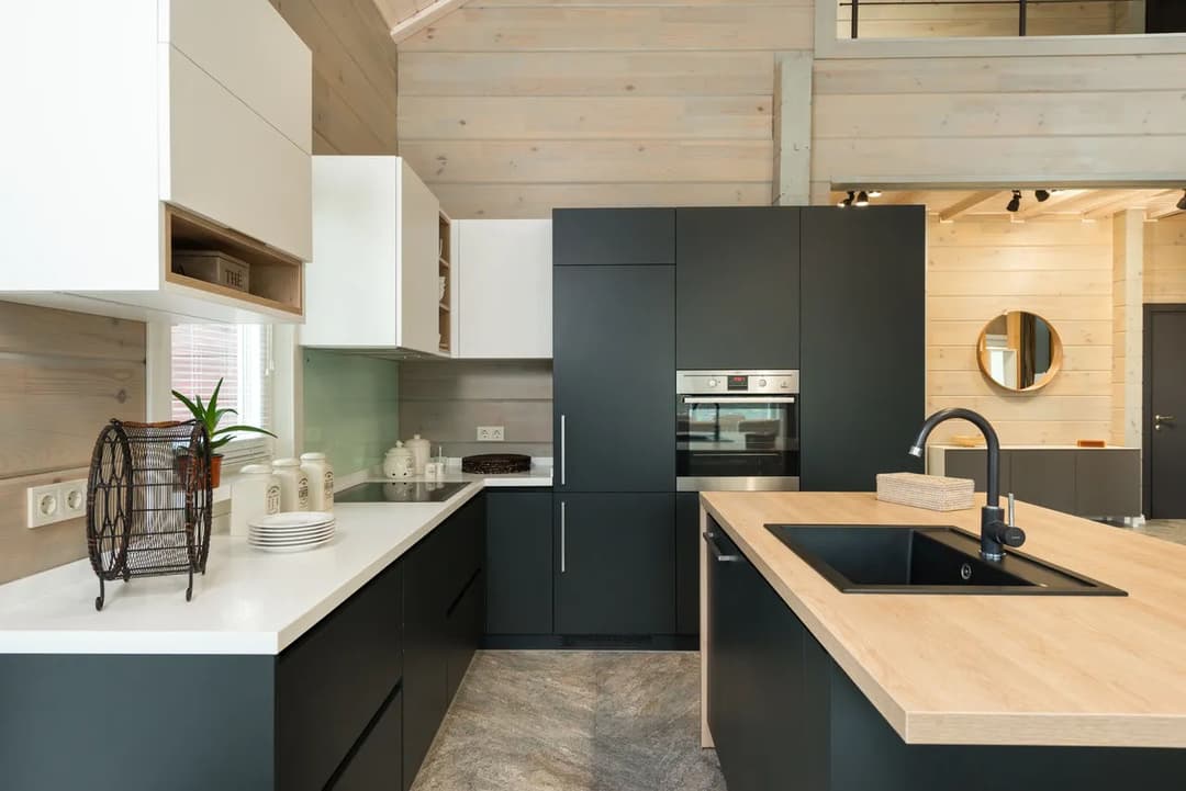 Modern kitchen with dark cabinetry, light countertops, and wood accents in a spacious design.
