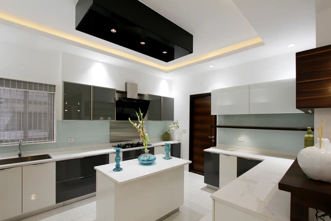 Modern kitchen with sleek cabinets, central island, and contemporary lighting.