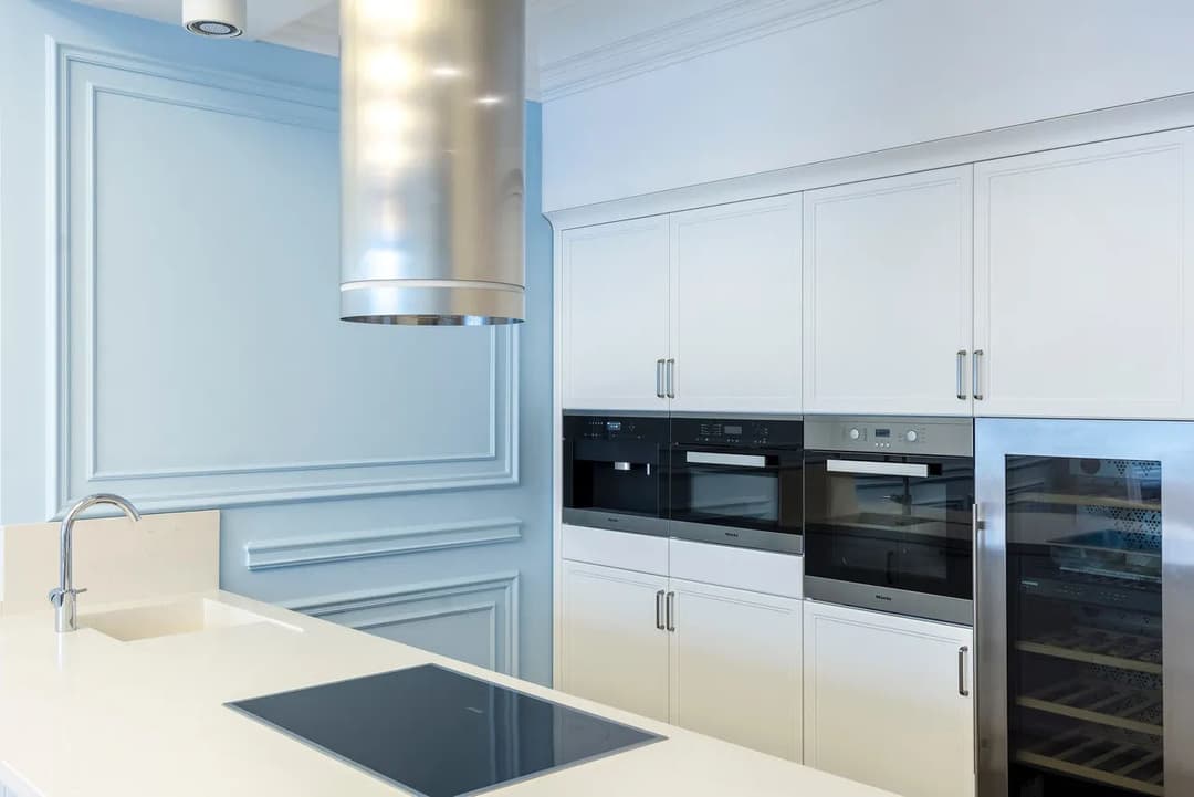 Modern kitchen with sleek white cabinetry, built-in appliances, and minimalist design.