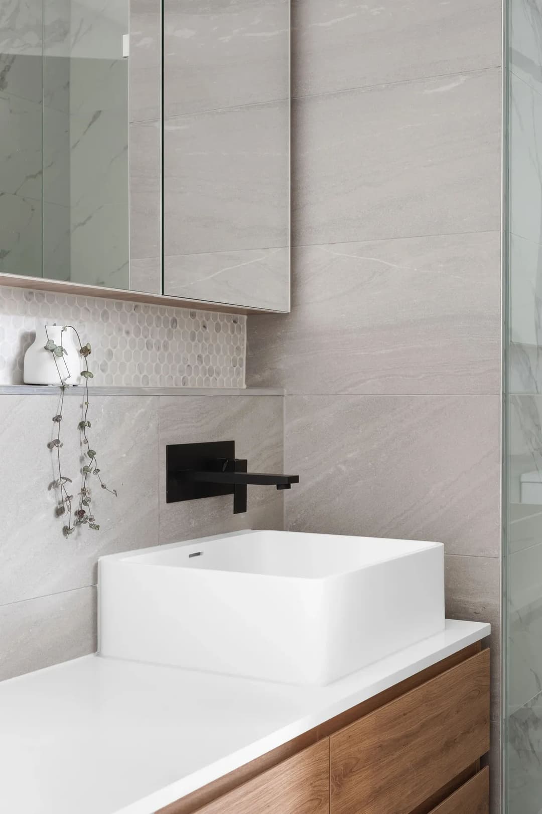 Modern bathroom design featuring a sleek white sink, black faucet, and minimalist decor.