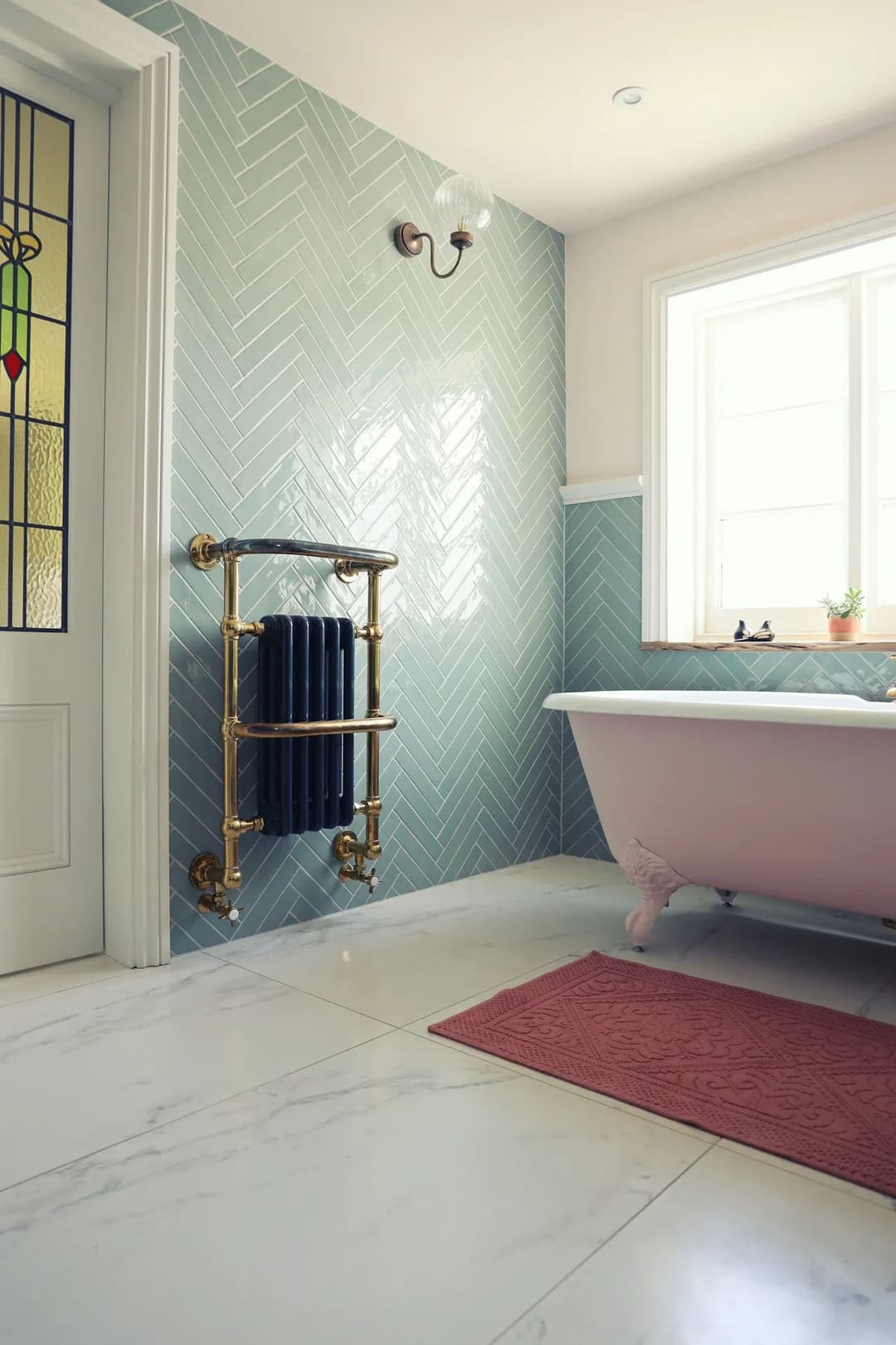 Elegant bathroom featuring a vintage tub, herringbone tiles, and a stylish radiator.