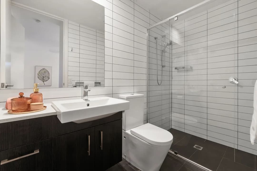 Modern bathroom with glass shower, sleek sink, and elegant decor accents.