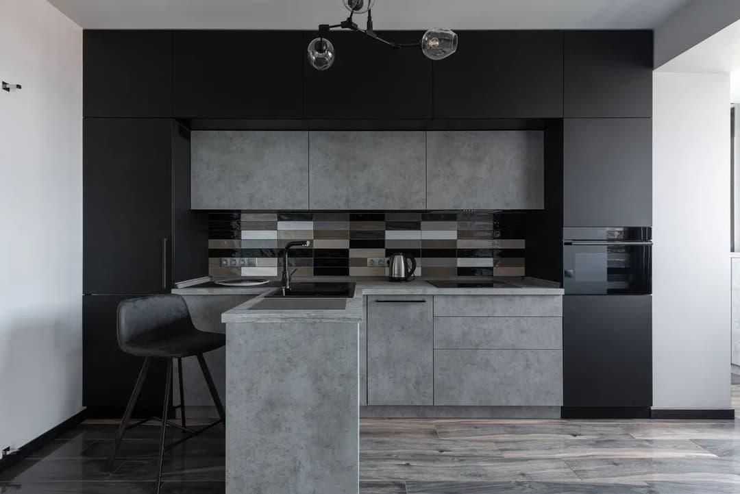 Modern minimalist kitchen with gray cabinetry, sleek design, and stylish pendant lighting.