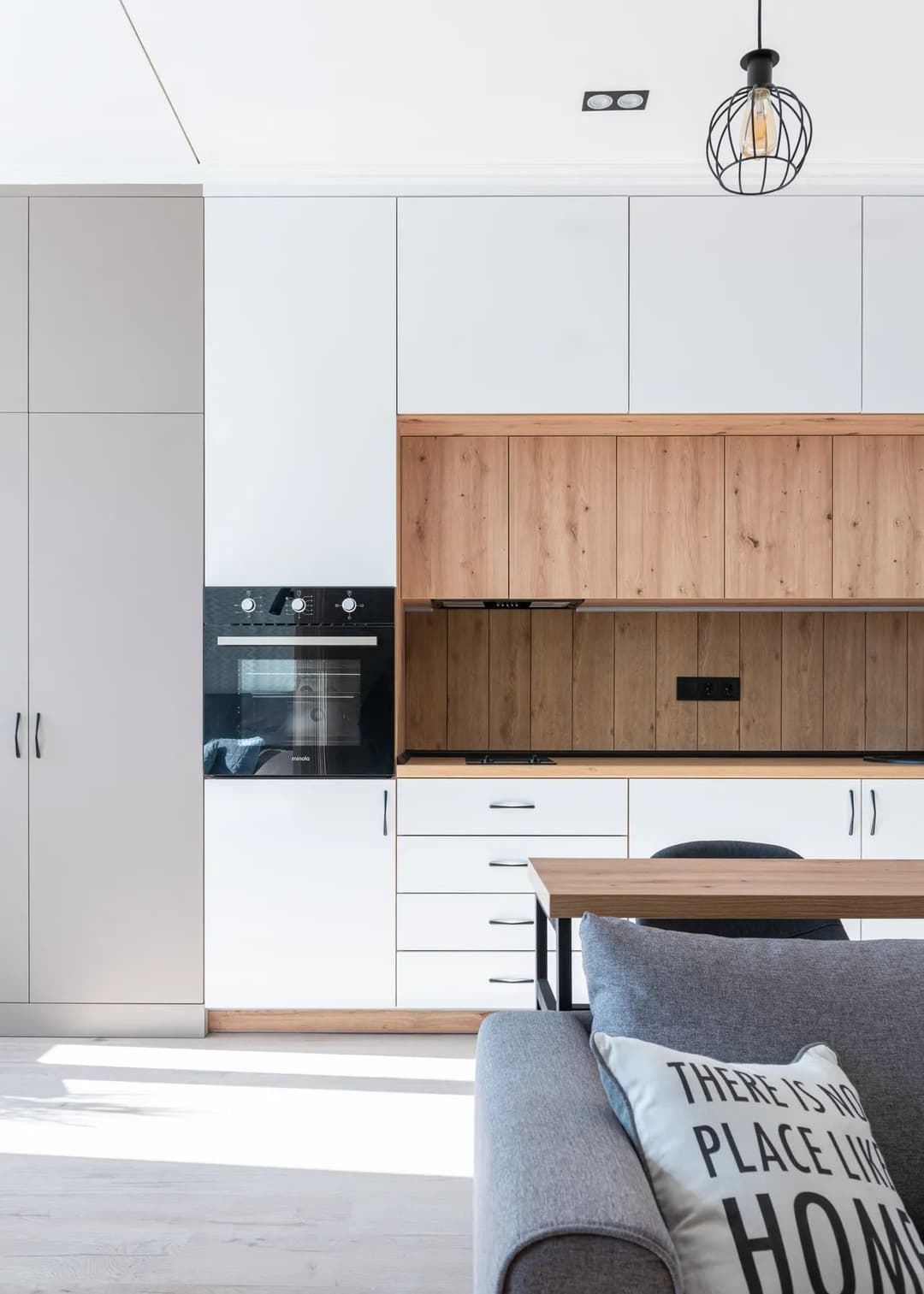 Modern kitchen design with white cabinets, wooden accents, and sleek appliances.